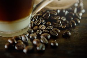 a cup of coffee sitting next to a pile of coffee beans